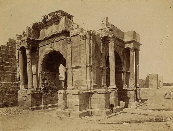 Historical photograph of the ruined arches and columns of a Roman-era Christian basilica in North Africa